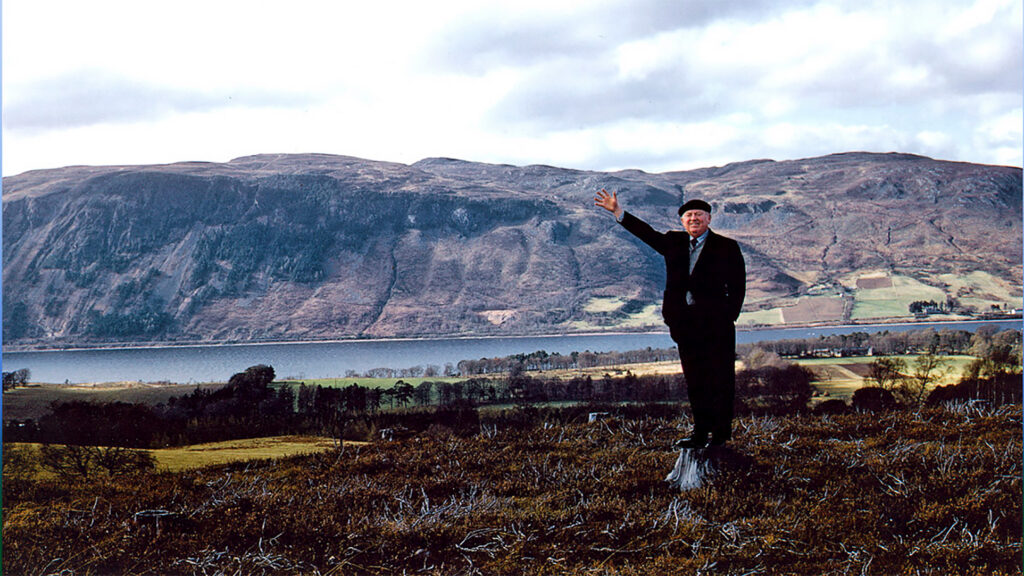 Hughston McBain at McBain Memorial Park about 1961, with Dores and Loch Ness behind
